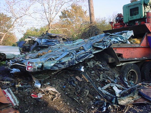A flattened car leaving a crusher